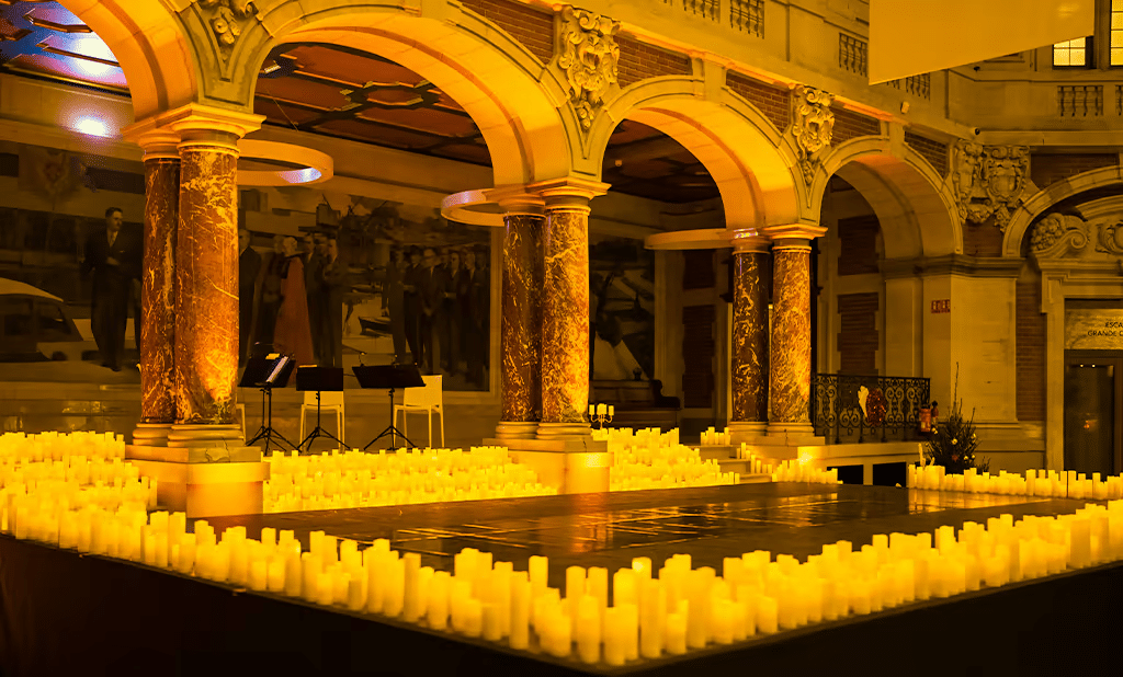 Concert Candlelight au Palais de la bourse à Lille. Scène carrée entourée de bougies sous les arches de la salle